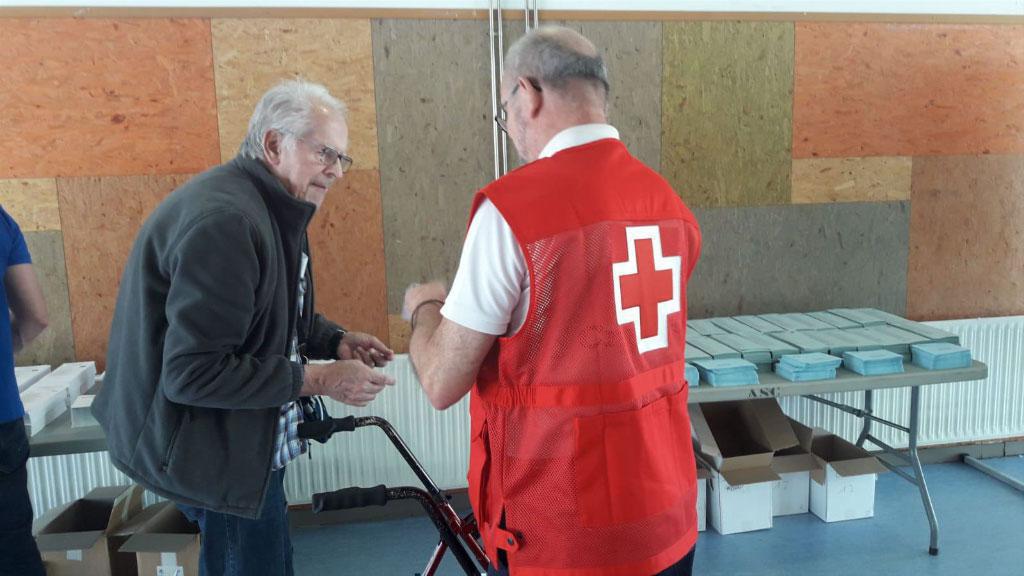 Un voluntari de Creu Roja amb una persona amb mobilitat reduda  / Foto: Cugat.cat